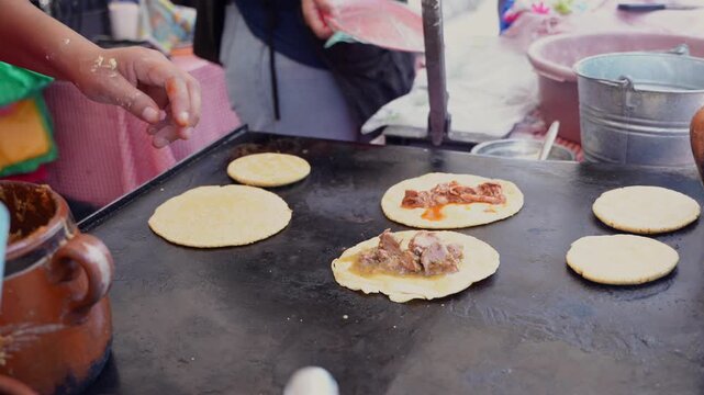 Mexican street food cook preparing gorditas on comal
