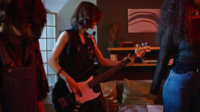 Diverse teenagers playing musical instruments and singing during band rehearsal at home. Footage represents youth culture, music education, and creative hobby marketing campaigns