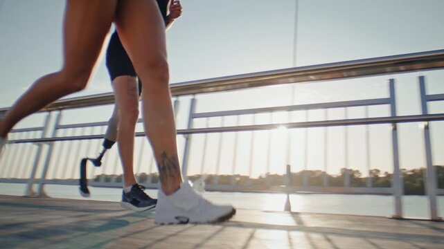 Fitness group runs together along modern riverside footbridge