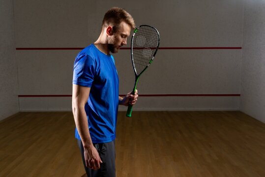 Squash player holding a racket inside the court