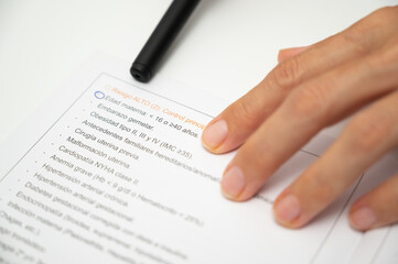Obraz premium Hand checking high risk pregnancy medical form