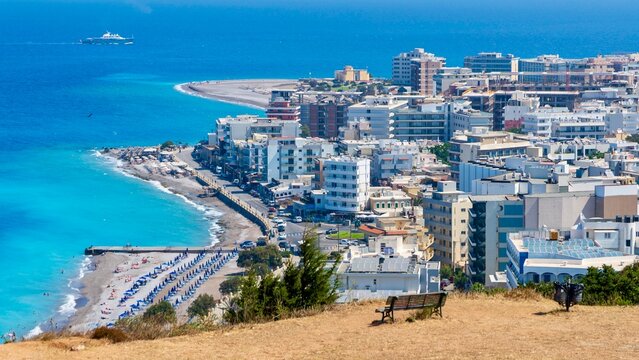 Rhodes, Greece - August 13, 2026: View of Paralia Elli beach on Rhodes Island, Greece, showing blue Aegean Sea, sandy and pebbled shoreline, and lively summer seaside atmosphere
