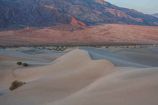 Beautiful scenic view of sand dunes and rugged mountains at sunrise