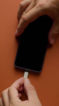 Top view close up of plugging and unplugging USB-C cable into smartphone vertical video