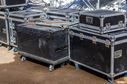 Stacked Road Cases with Wheels on Asphalt Surface