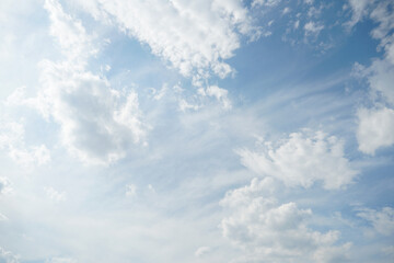Fototapeta premium White fluffy clouds in the sky. Blue sky and cloud cover on a sunny summer day. Empty background, copy space