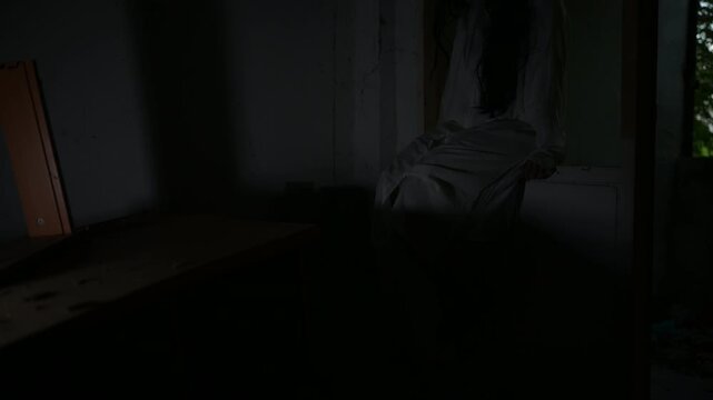 Dark horror scene of a mysterious figure in a white dress sitting alone in a dim abandoned room. Eerie shadows create a supernatural atmosphere for haunted house, paranormal and Halloween concepts.