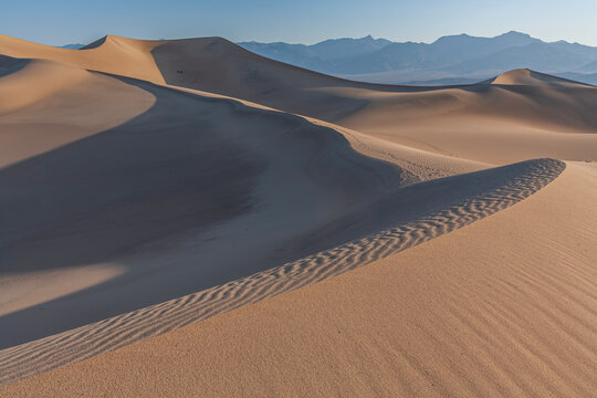 Beautiful scenic view of abstract sand dunes texture with curved shadow ridge