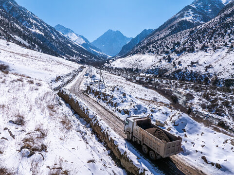 Dump Truck Hauling Gravel on Snowy Mountain Road