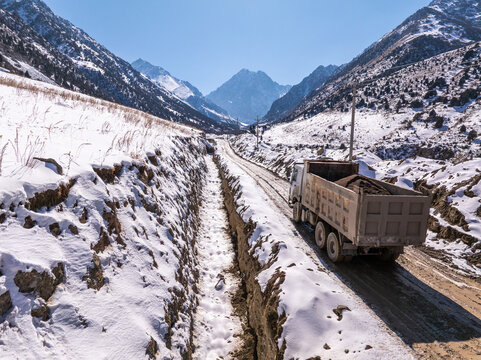 Dump Truck Hauling Soil on Snowy Mountain Road