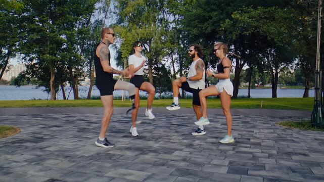 Runners perform high knee warmup together in green park