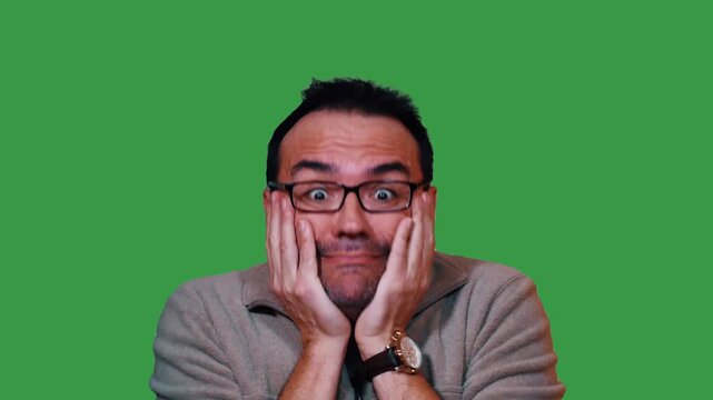 Funny shocked man with glasses holds his face and screams with a wide-eyed expression on green screen, conveying surprise, disgust, fear or disbelief. 15320