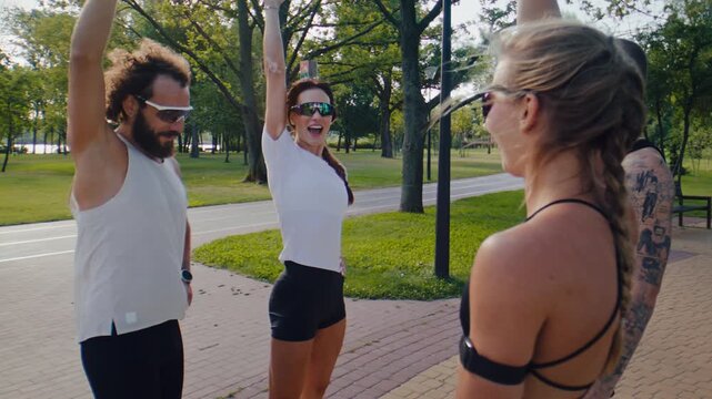 Athletes stack hands together after finishing group park workout