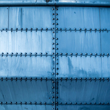 Blue painted metal ship hull with rivets industrial nautical texture background