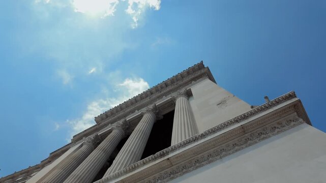 Low angle architectural view of Corinthian marble columns at Altare della Patria against blue sky