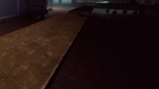 A close view of a wooden table in a dark room. The table shows signs of use. Light from the background highlights parts of the table. The setting appears to be informal.