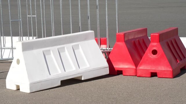 Modular plastic jersey barriers and interlocking steel pedestrian barricades installed for perimeter safety and road closure controls