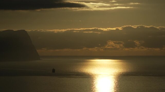 Sunset ocean ship majestic sunset over the calm ocean with a silhouetted ship and rugged coastal cliffs