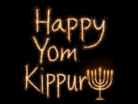 Happy yom kippur glowing text with menorah light display