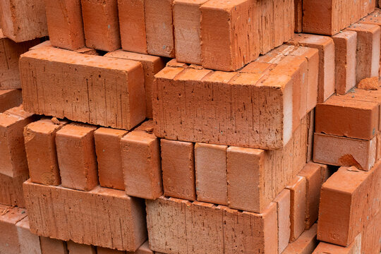 Close-up of stacked red clay building bricks