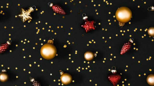 Christmas  Pattern Background with Gold and Red Baubles, Stars and Pine Cones On Black. Festive Winter Holiday Flat Lay Ornament For Wallpaper, Wrapping Paper, Greeting Card Or Banner