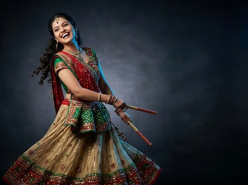 Happy indian woman dancing garba with dandiya sticks in traditional attire