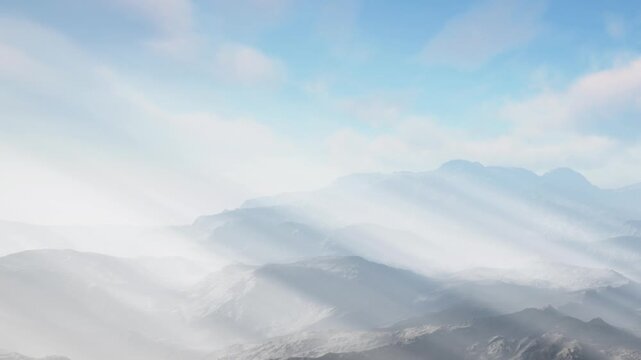 Mountains stretch across the landscape with light fog covering the valleys. The sky is blue with some clouds, creating a scenic view early in the day.