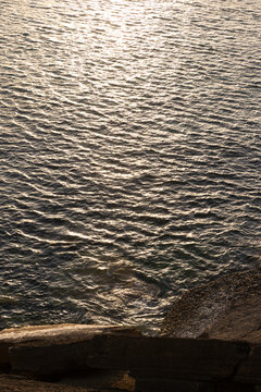 high angle view of Portugese coast at golden hour with glimmer on water texture, minimal