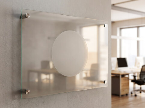 Modern frosted glass sign board mounted on a concrete wall in a bright office interior