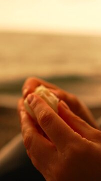 Hands egg sunset person peeling a soft boiled egg on a beach during a warm golden hour evening