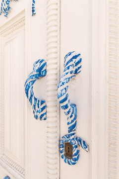 traditional white building with closeup of door handle painted in nautical rope style