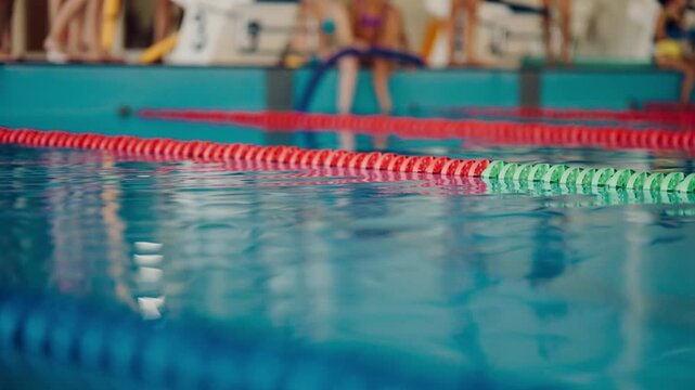Swimmers prepare for a race at an indoor swimming pool in the afternoon
