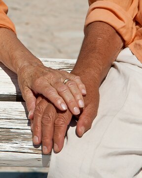 Close-up of senior person resting hands on knee outdoors