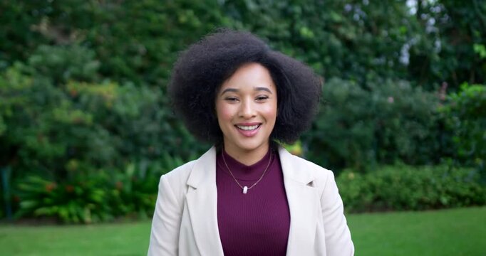Adult woman presenting on camera standing on lawn wearing blazer and necklaces gradually smiling