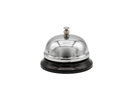 A classic silver hotel reception desk bell with a black circular base, isolated on a solid black background, for hospitality service concepts