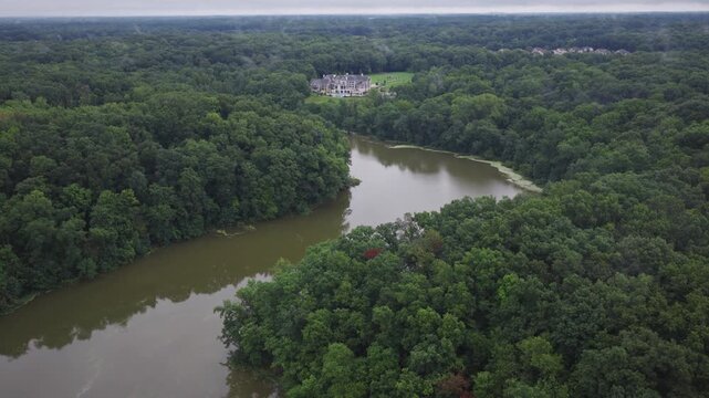 Drone aerial of big house mansion home and upper class income residential living along big walnut creek water river way outside Columbus and Galena, OH in Ohio landscape with trees, woods, and forest