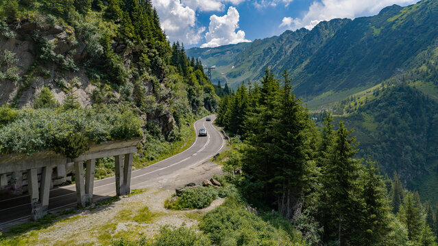 Aerial view of the winding Transfagarasan road featuring a concrete gallery and lush pine forests nestled in the steep mountains of Curtea de Arges, Arges, Romania.