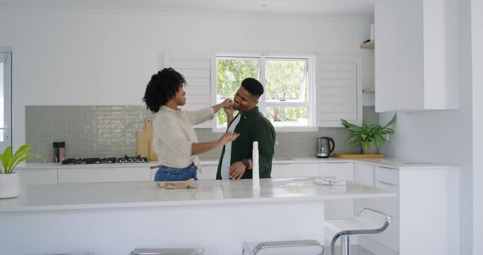 African American couple showing love after man coming and speaking while wiping counter on island