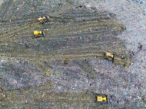 Aerial view of bulldozers working at the Amin Bazar Waste Disposal Area, managing waste in a large landfill in Bongaon Union, Dhaka Division, Bangladesh.