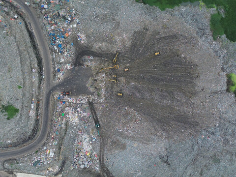 Aerial view of Amin Bazar Waste Disposal Area with heavy machinery and excavators working on the landfill site in Bongaon Union, Dhaka Division, Bangladesh.