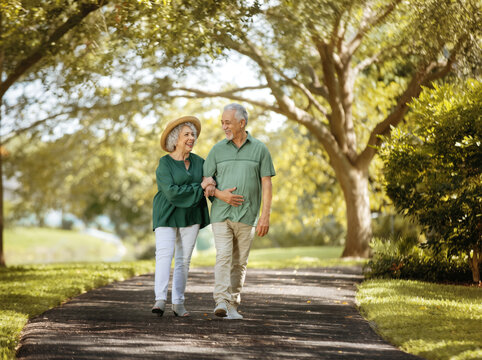 senior couple walking in park smiling
