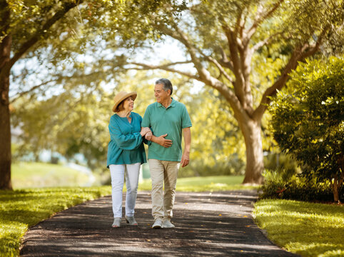 senior couple walking in the park smiling