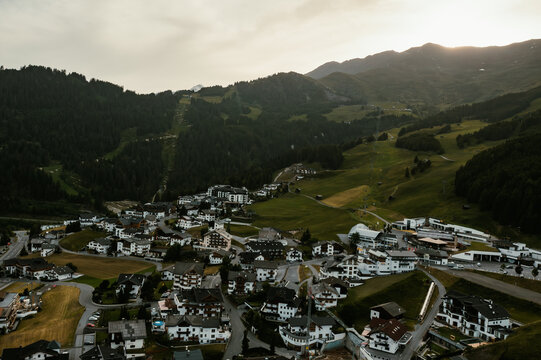 Aerial view of the village of Fiss nestled in the green meadows of the Tyrolean Alps with traditional architecture and surrounding mountain slopes, Fiss, Tyrol, Austria.