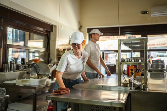 Kitchen staff cleaning commercial restaurant prep area