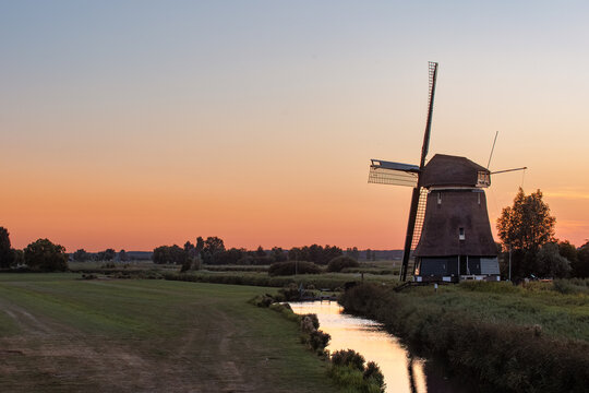 De Kathammer windmill beside a canal at sunset