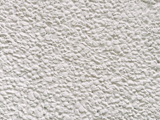 White pebbled stucco wall texture background. Coarse white aggregate plaster surface close up. © Oleksandr