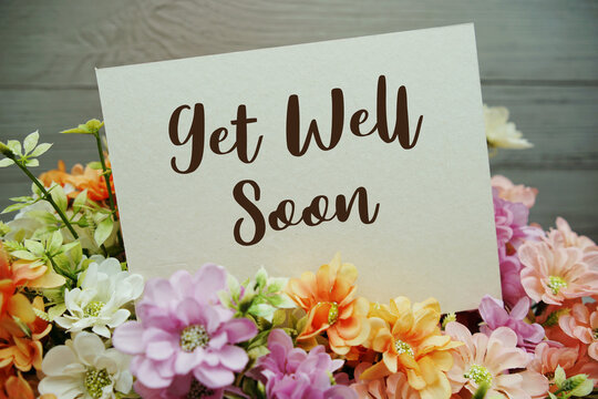 Get Well Soon text written on paper card with flowers decorations