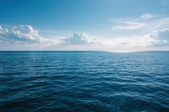 Open horizon over a tranquil sea under bright daylight and blue skies