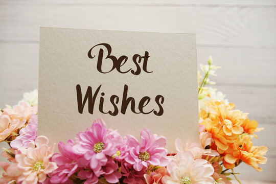 Best Wishes text written on paper card with flowers decorations