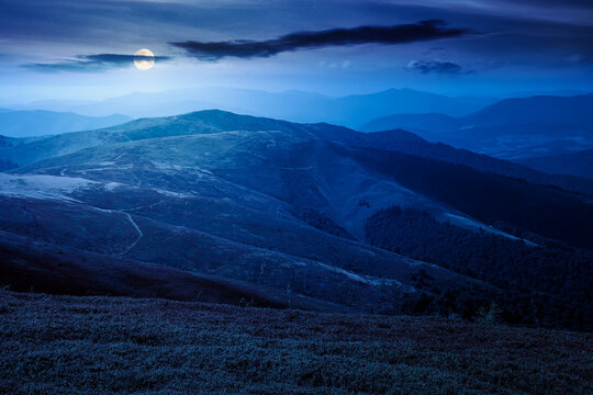 Carpathian mountain landscape in late summer at night. full moon over scenic view of Transcarpathia region from the Great Summit. mysterious alpine blueberry field on Polonyna Play hill